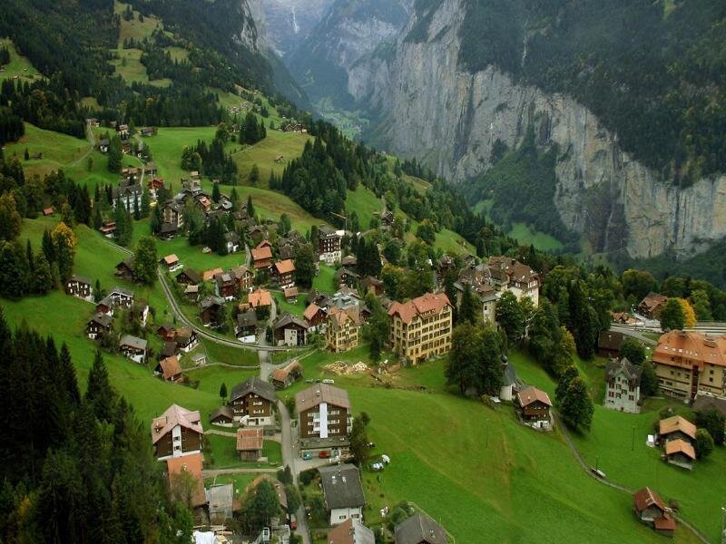Village in Alpine Valley — Green, Serene, Afternoon, Photograph, Mountains, Trees, Buildings
