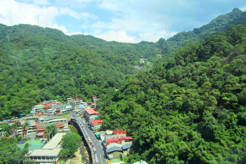 Village in Mountain Valley — Green, Serene, Afternoon, Photograph, Mountains, Buildings, Road