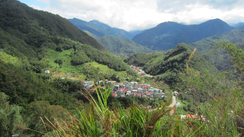 Village in Mountain Valley — Green, Serene, Afternoon, Photograph, Mountains, Buildings, Vegetation