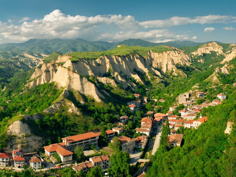 Village in Mountain Valley — Green, Serene, Afternoon, Photograph, Mountains, Cliffs