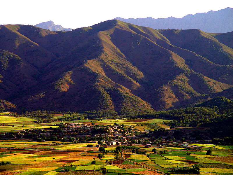 Village in Mountain Valley — Green, Serene, Afternoon, Photograph, Mountains, Fields