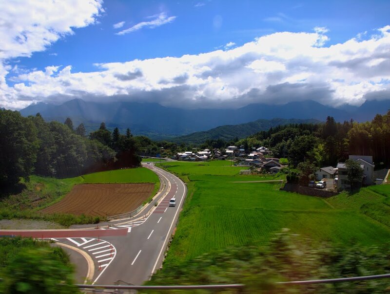 Village in Mountain Valley — Green, Serene, Afternoon, Photograph, Road