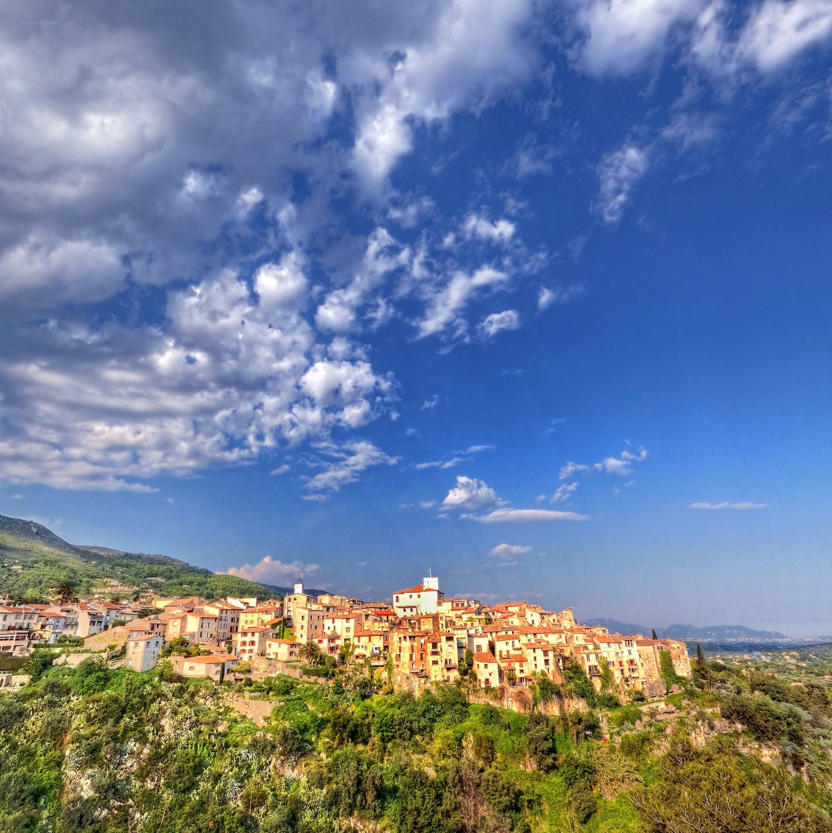village on a hill under cloudy sky
