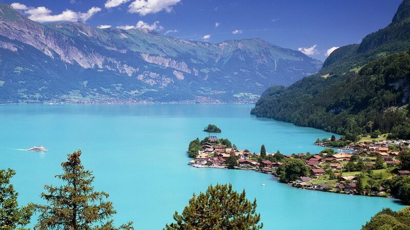 Village on Lake Island — Blue, Serene, Afternoon, Photograph, Mountains, Boat, Trees, Green, Brown