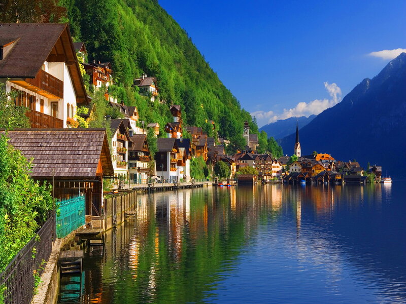 Village on Lake Shore — Blue, Serene, Afternoon, Photograph, Mountains, Church, Houses