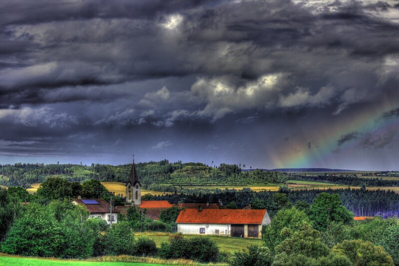 Village under stormy sky with rainbow
