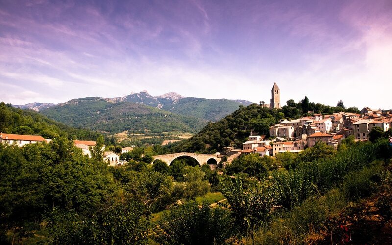 village with stone bridge and mountains