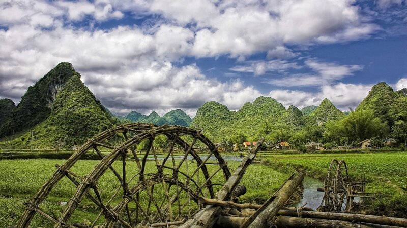 Village with waterwheels and karst mountains