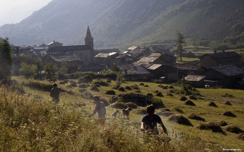 Villagers harvesting hay in a mountain valley