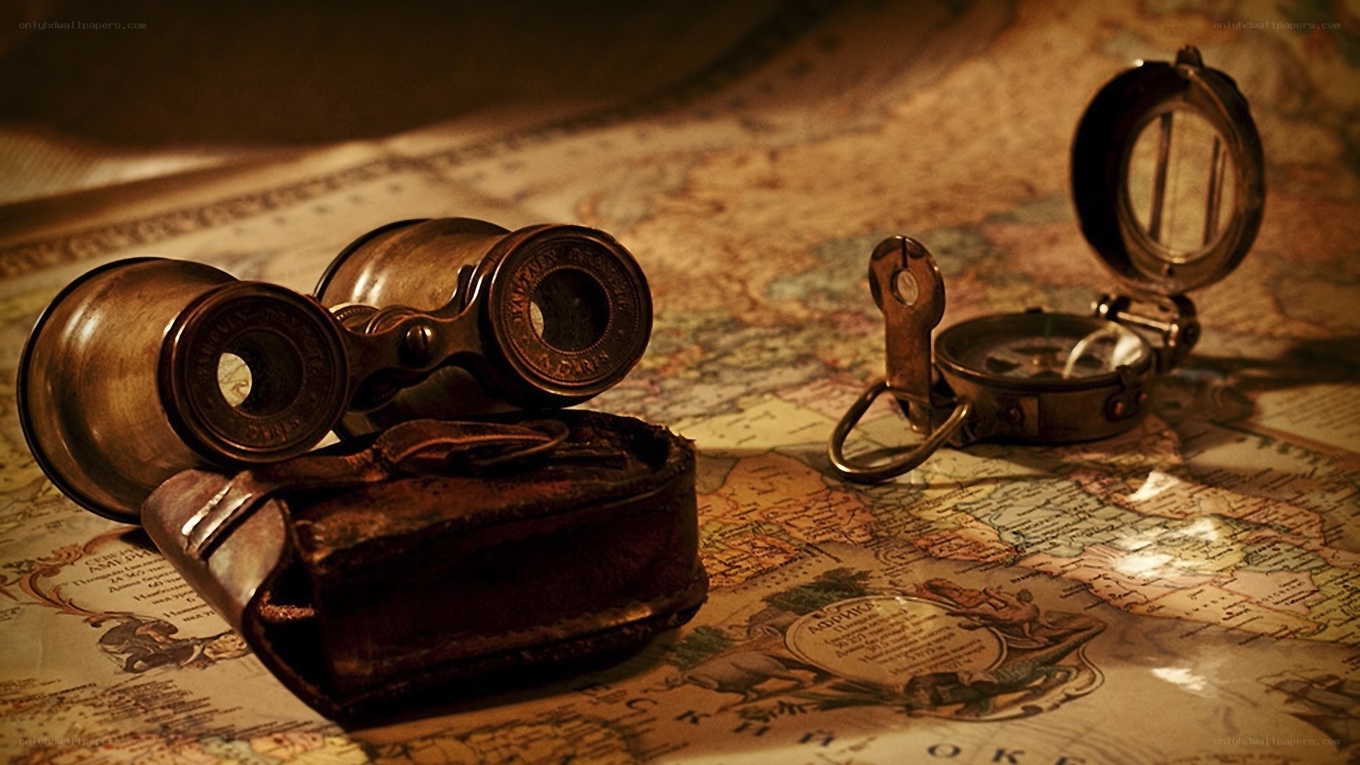 Vintage binoculars and compass on map