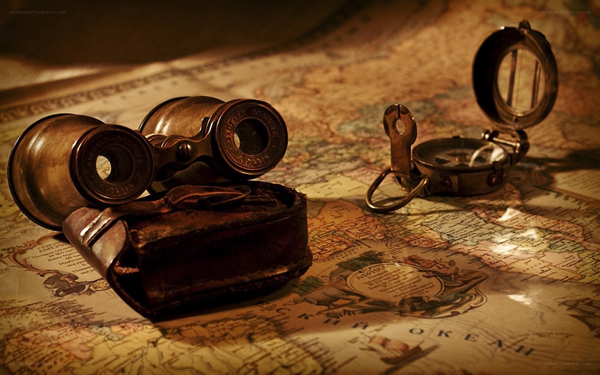 Vintage binoculars and compass on map