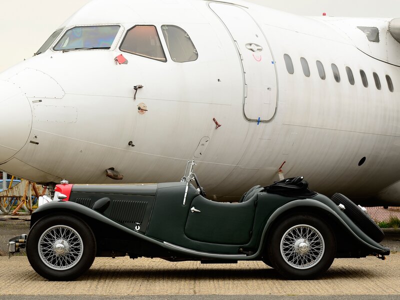Vintage car beside airplane