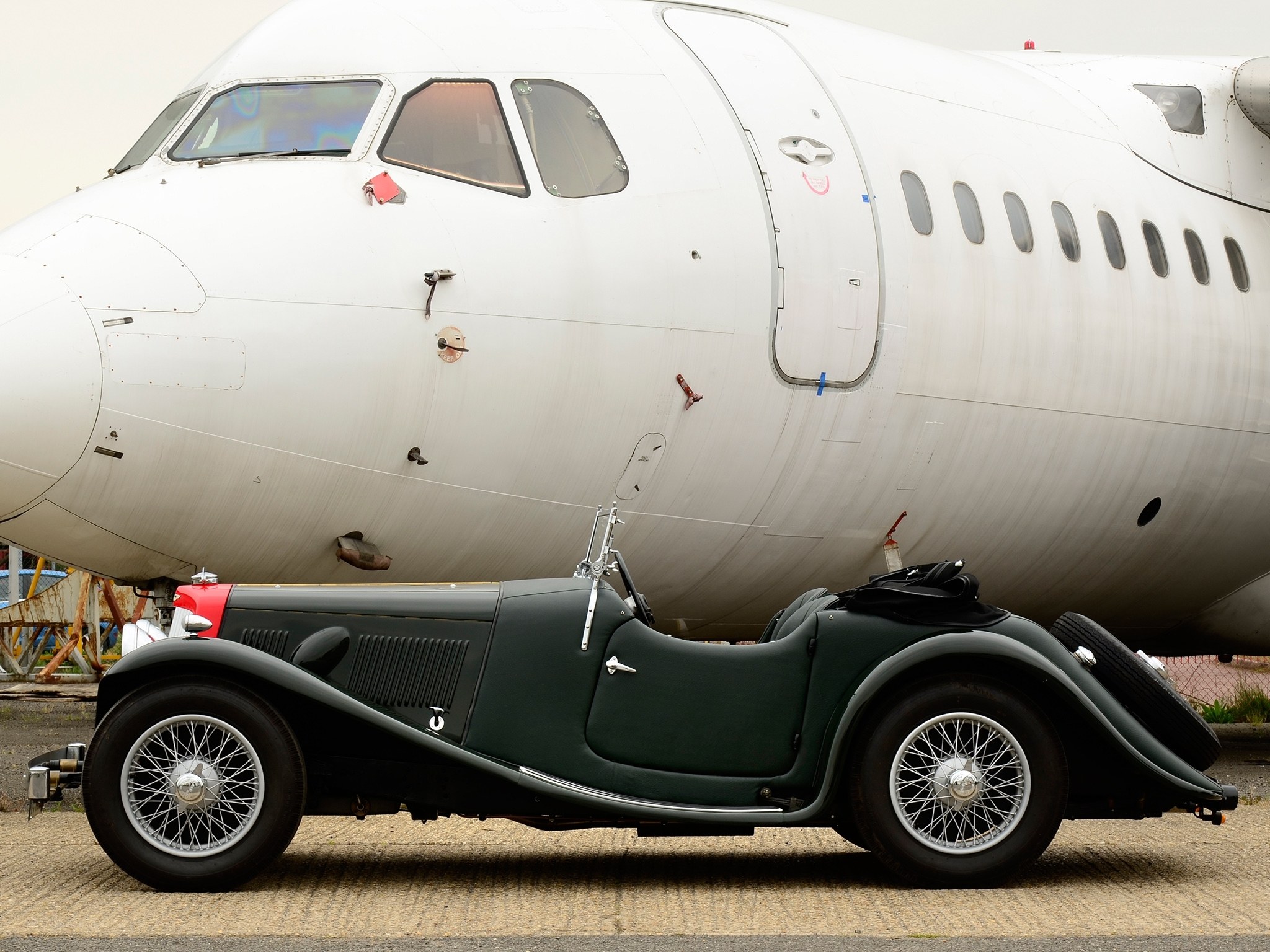 Vintage car beside airplane