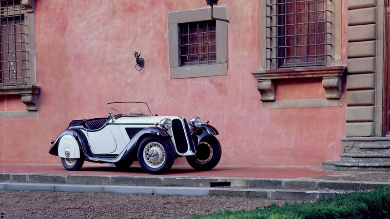 Vintage car by a pink building