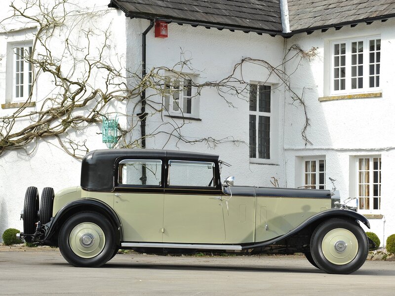 vintage car by a white house