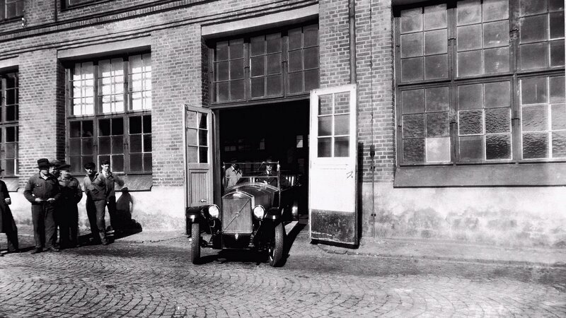 Vintage car exiting factory