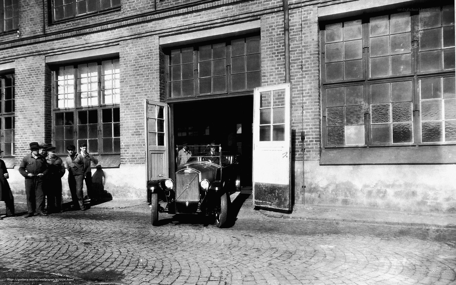 Vintage car exiting factory
