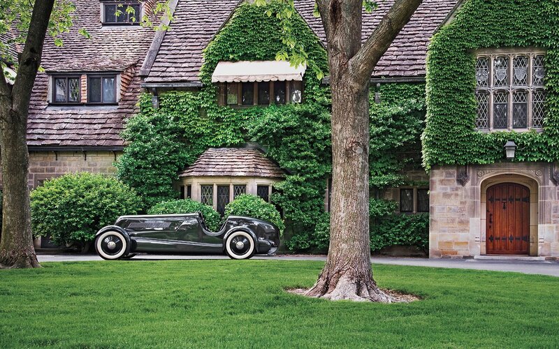 Vintage car in front of ivy-covered house