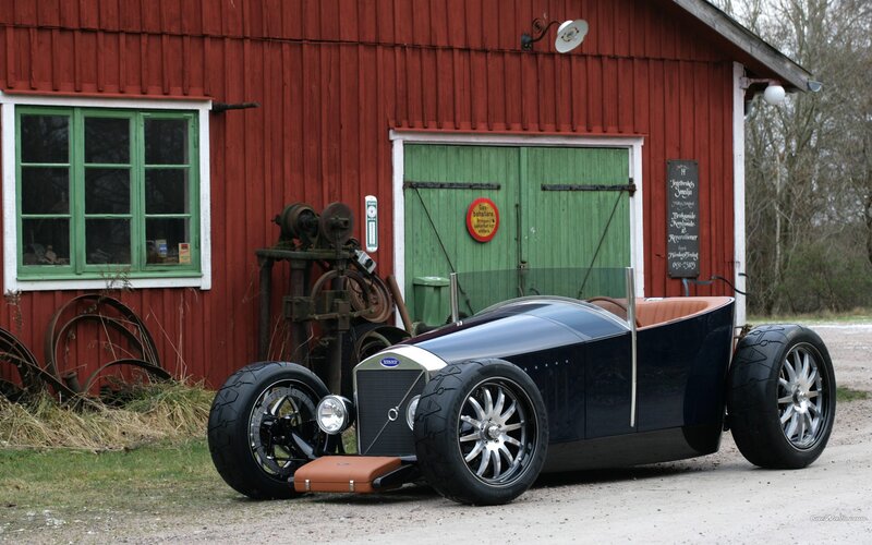vintage car in front of red barn