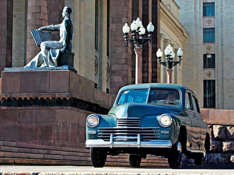 Vintage car in front of statue