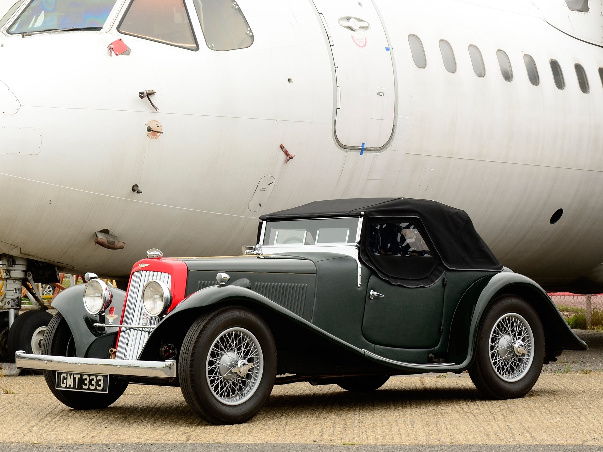 Vintage car near airplane