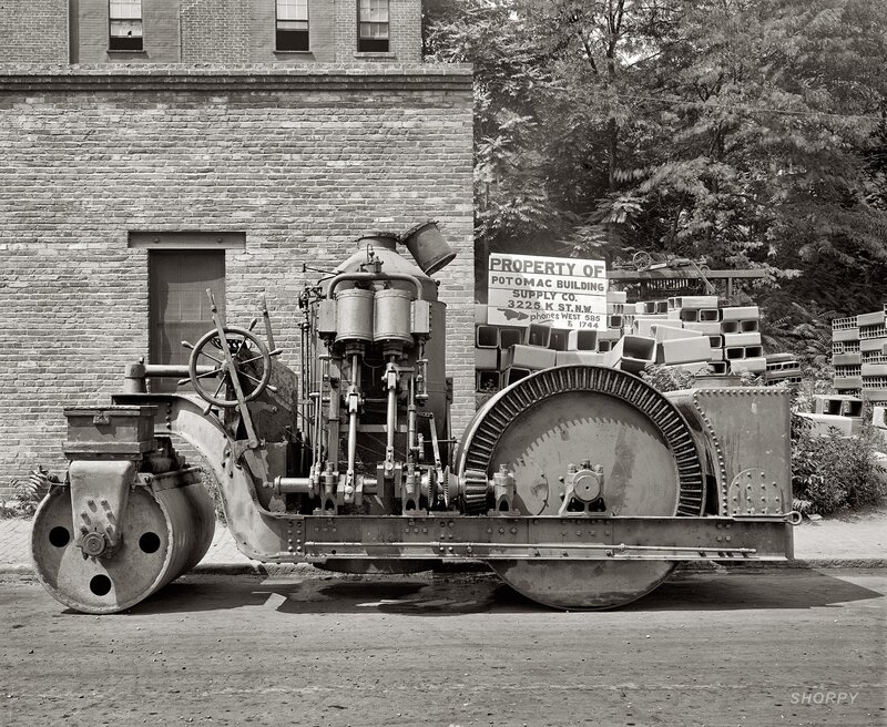 Vintage steam roller in front of brick building
