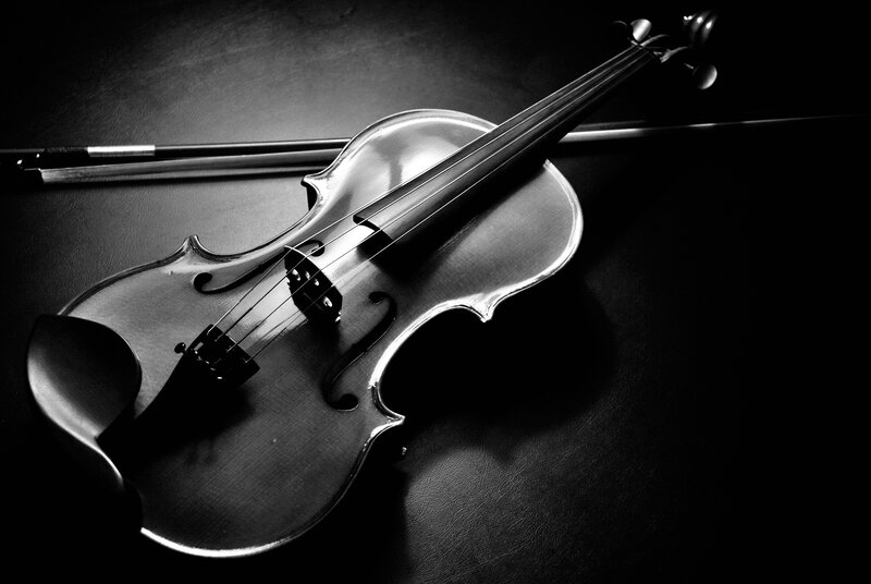 Violin and bow on dark surface