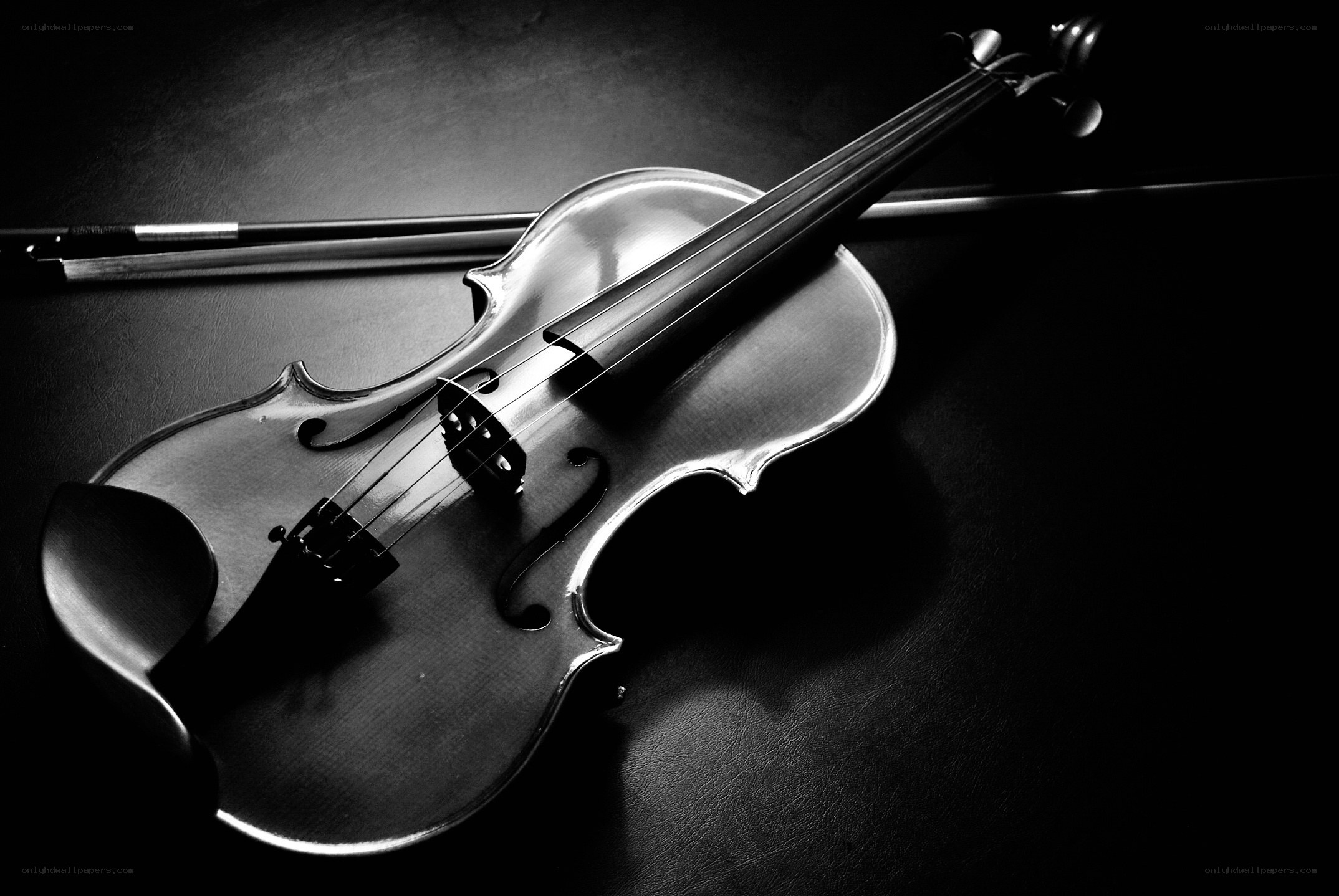 Violin and bow on dark surface