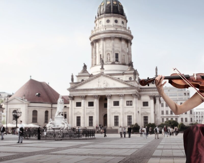 Violinist in front of a historic building