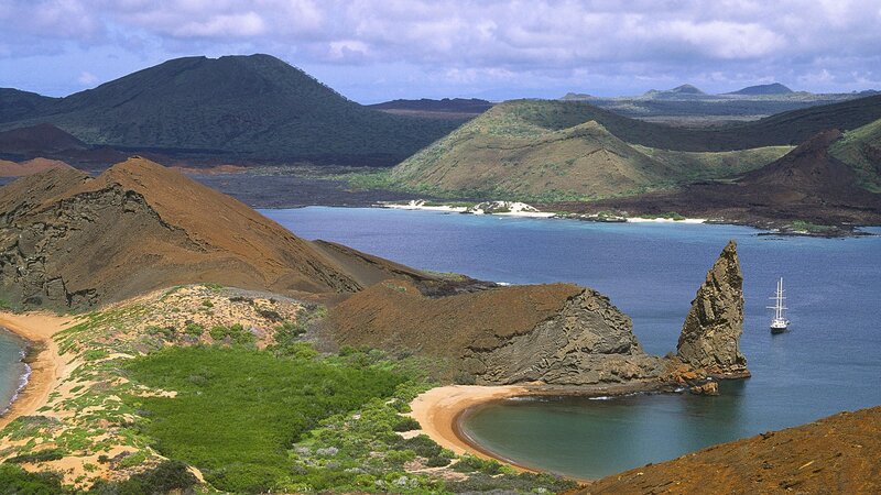 volcanic island bay with sailboat
