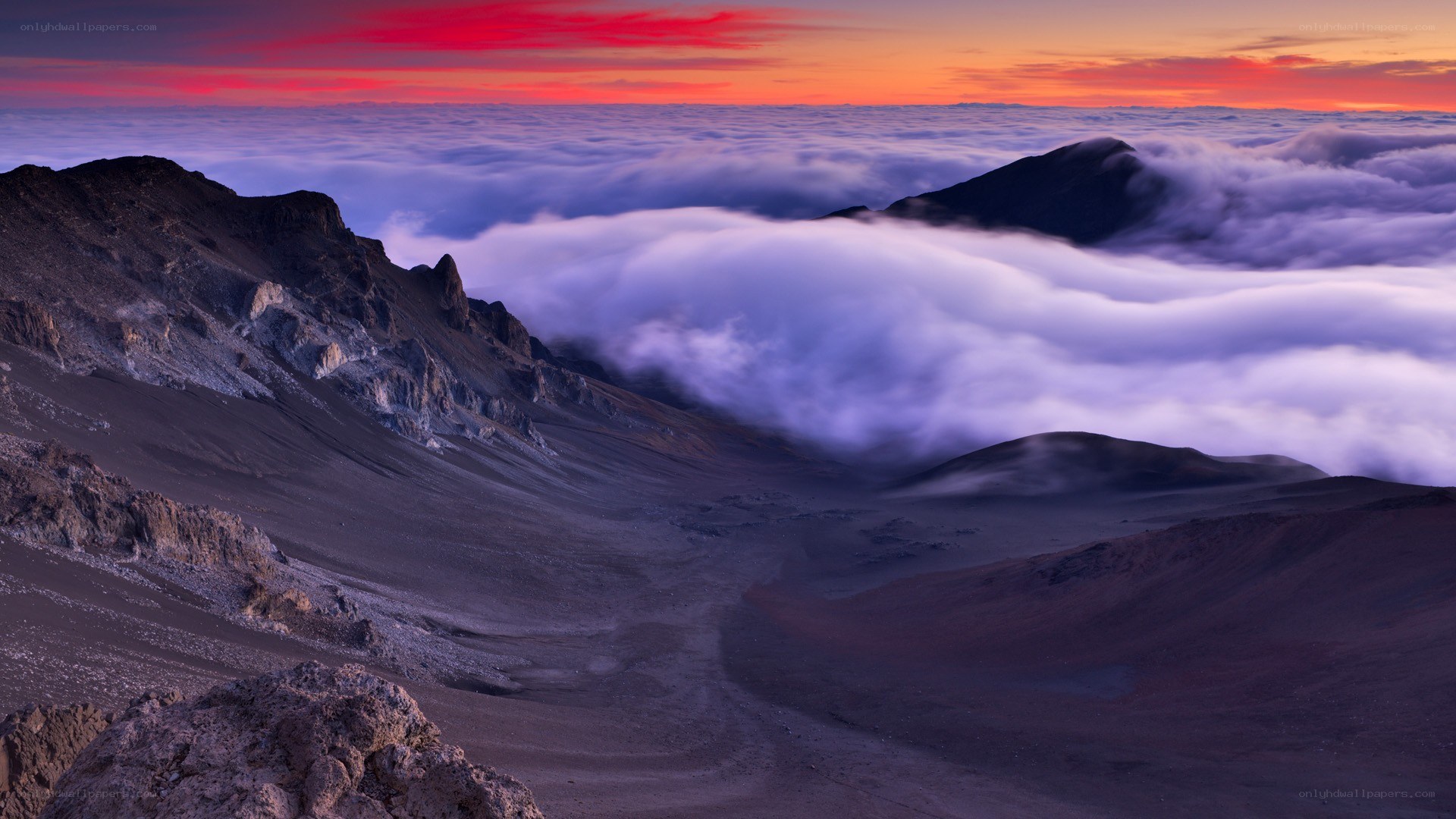 Volcanic peak above clouds at sunset