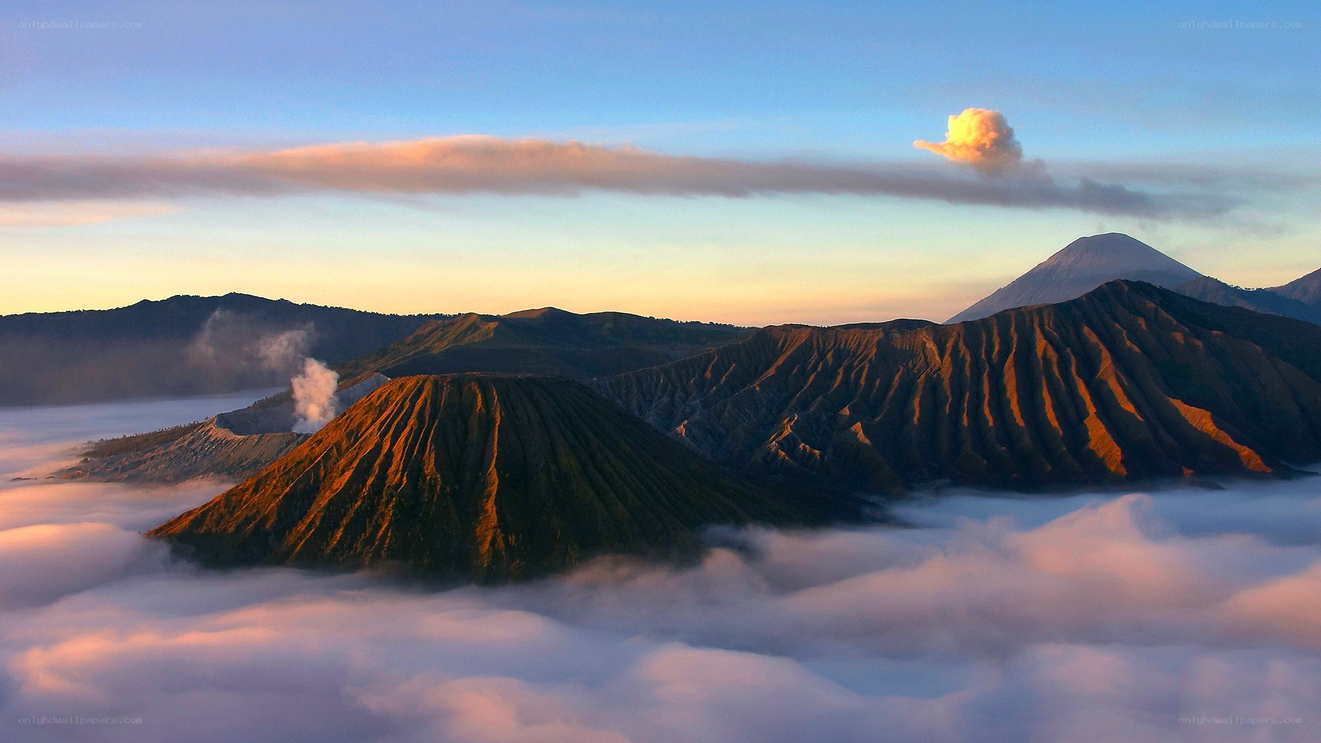 Volcanic peaks above clouds at sunrise