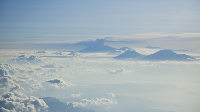 Volcanic Peaks Above Clouds — Blue