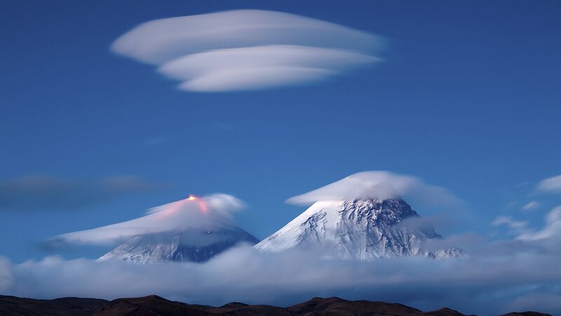 Volcanic peaks with lenticular clouds