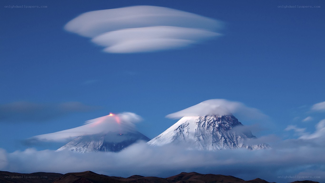 Volcanic peaks with lenticular clouds