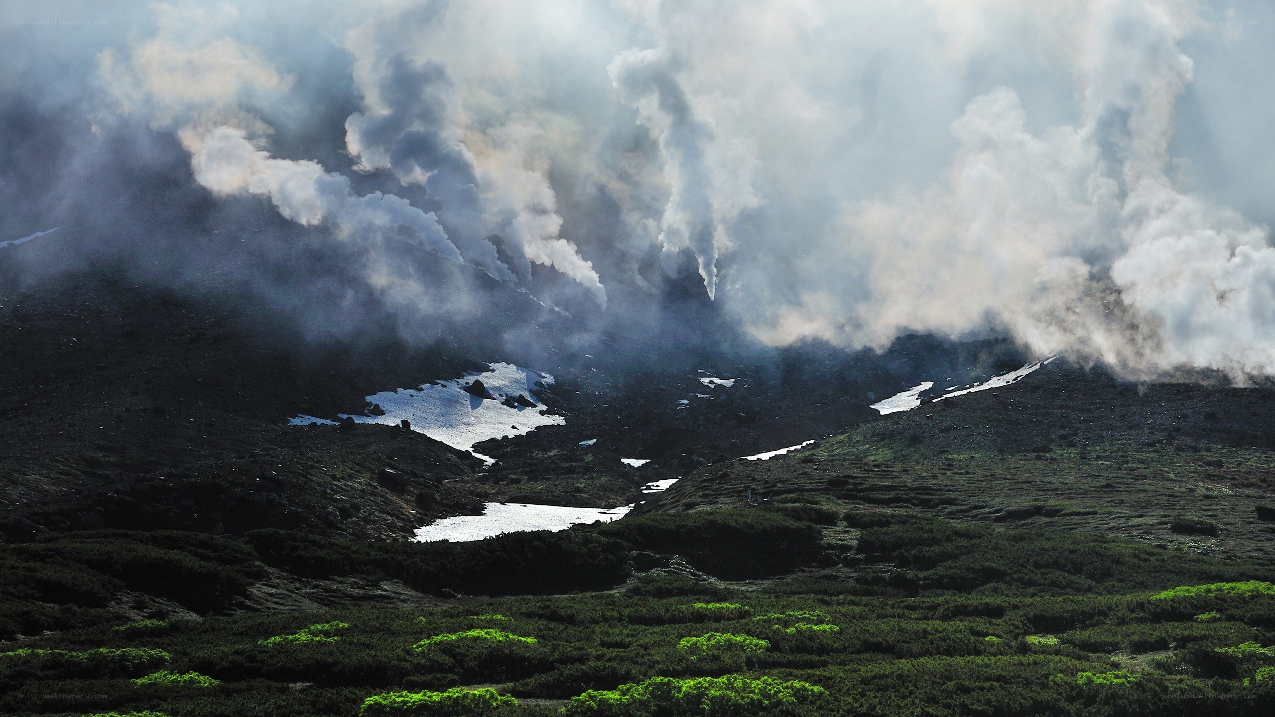 Volcanic plume over mountain landscape