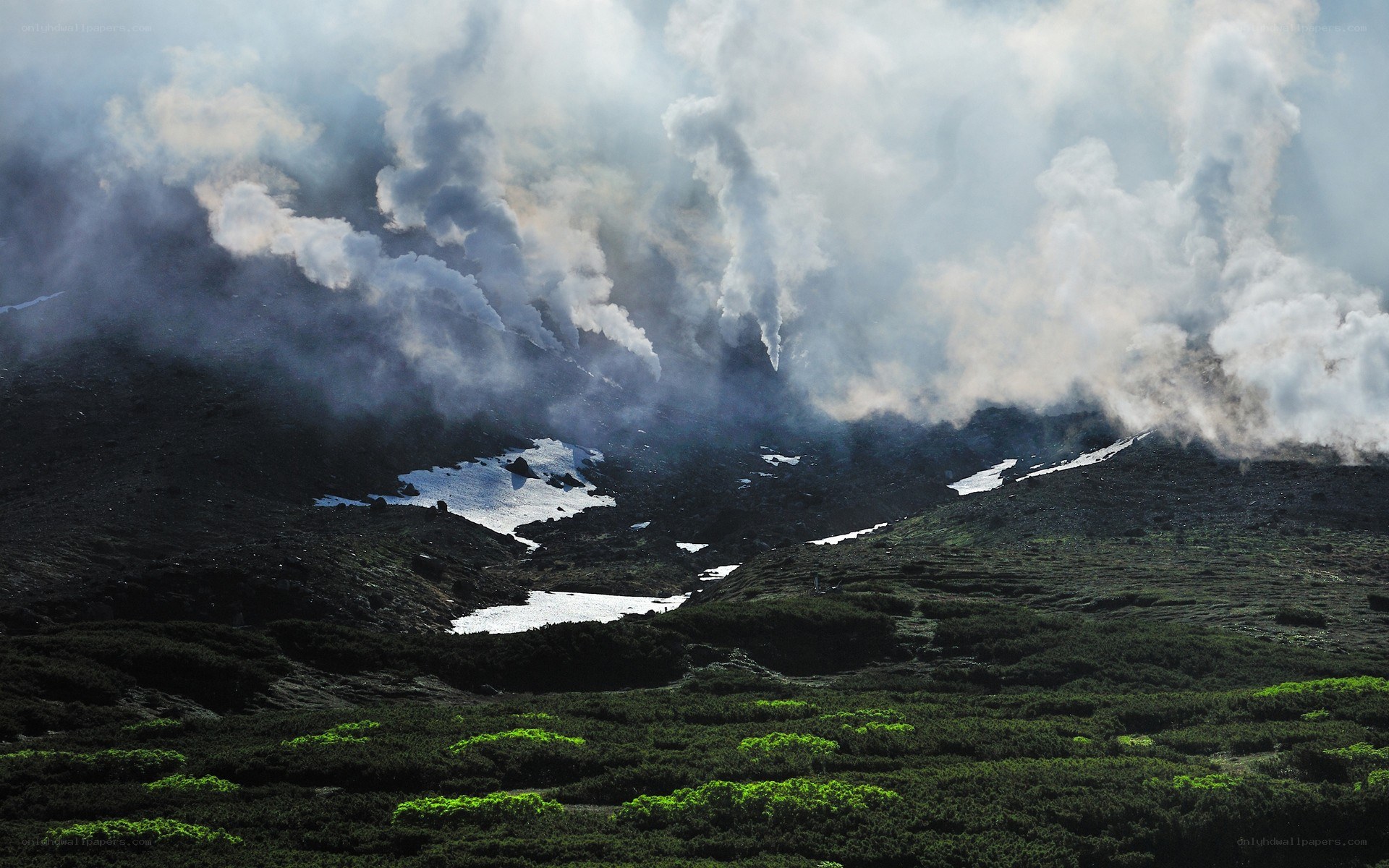 Volcanic smoke over a mountain landscape