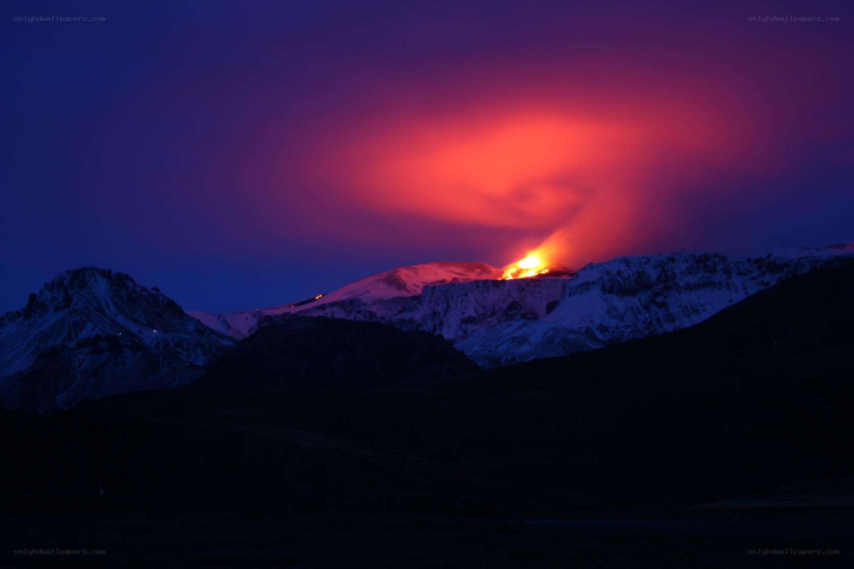 Volcano erupting at night