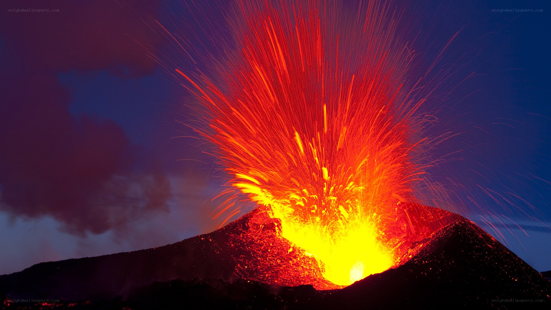 Volcano erupting at night