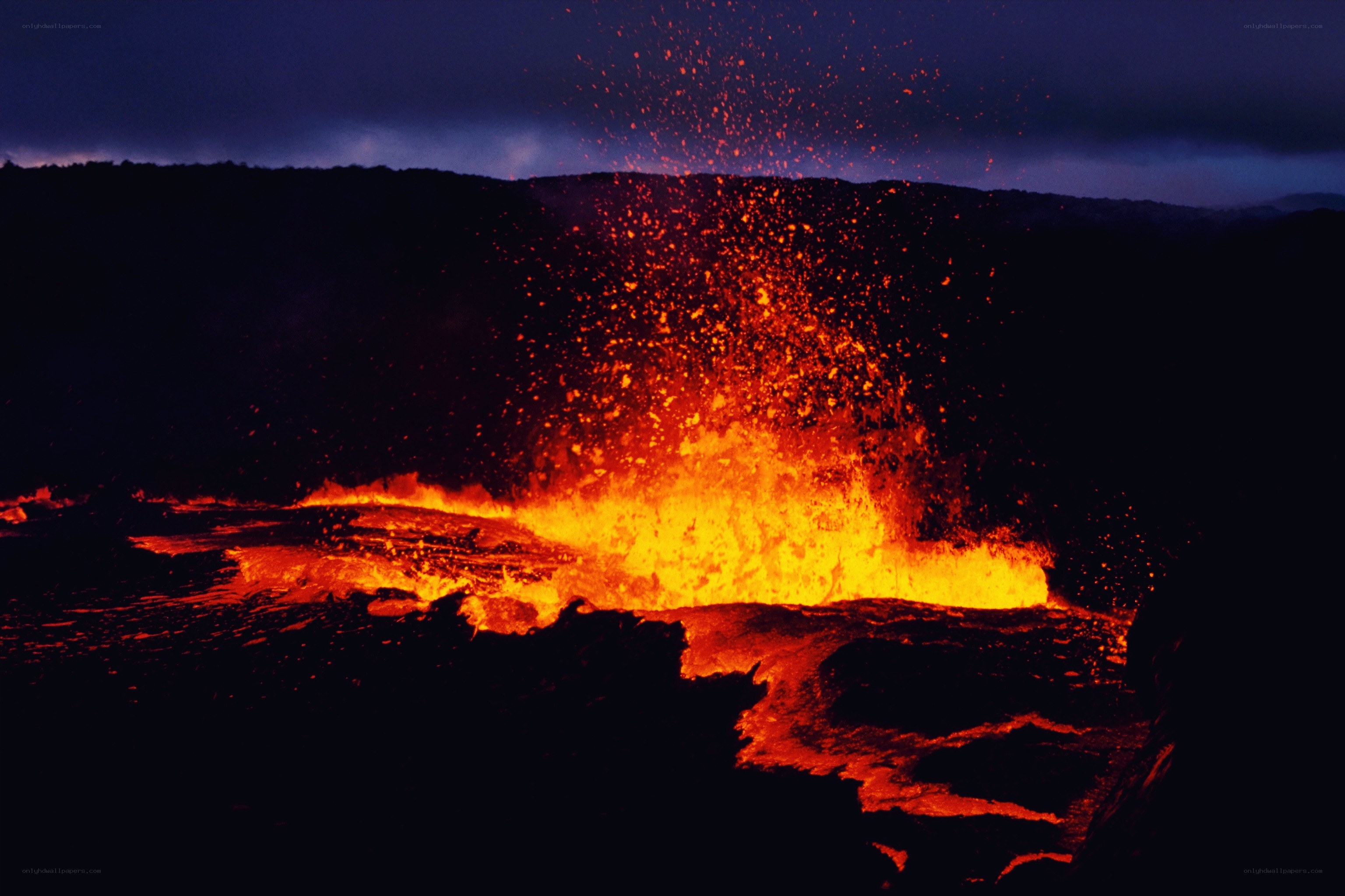 Volcano erupting at night