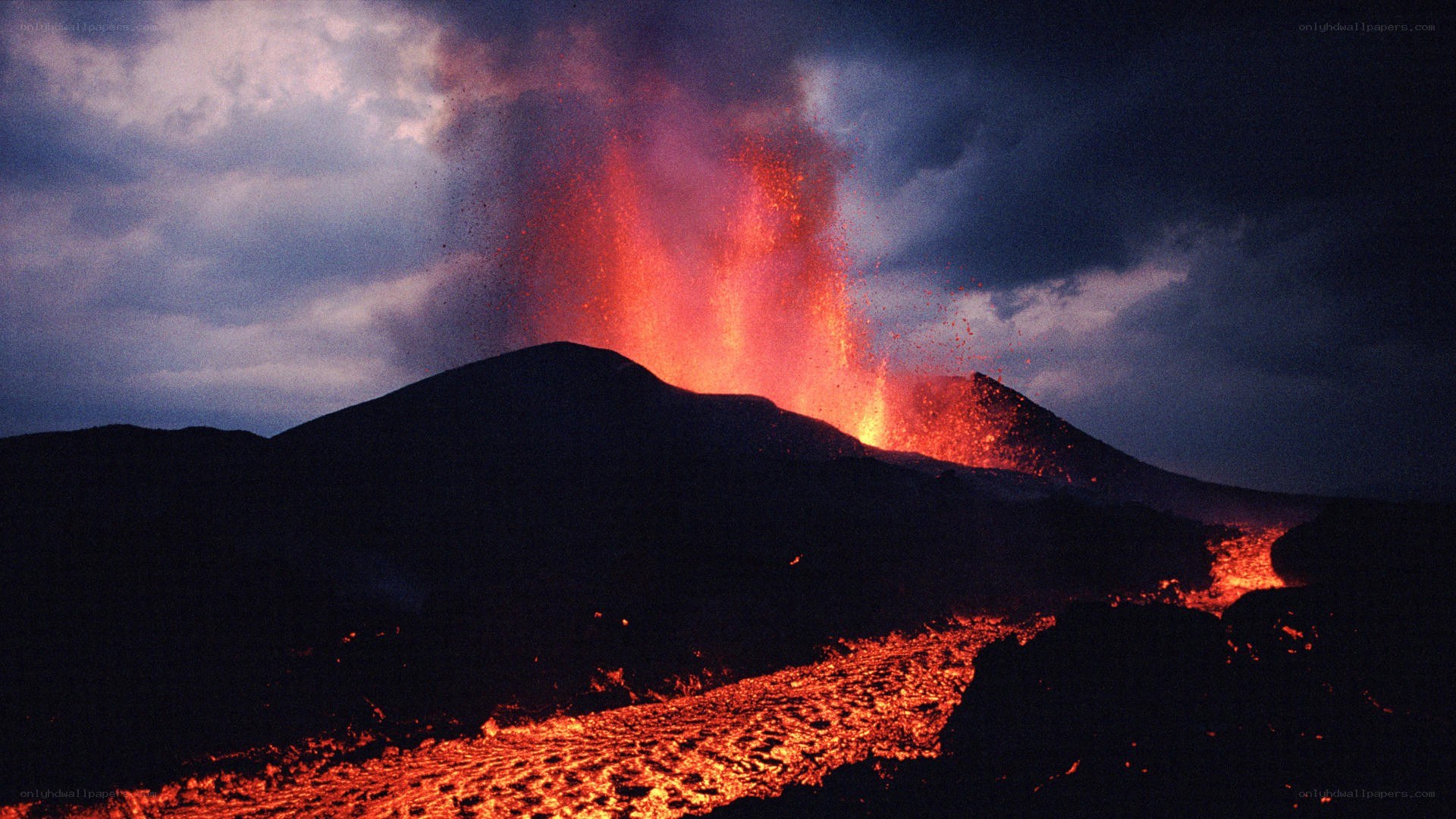 Volcano erupting at night