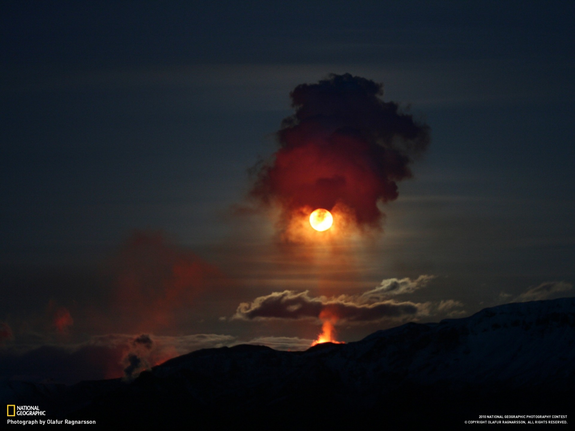 Volcano erupting at sunset