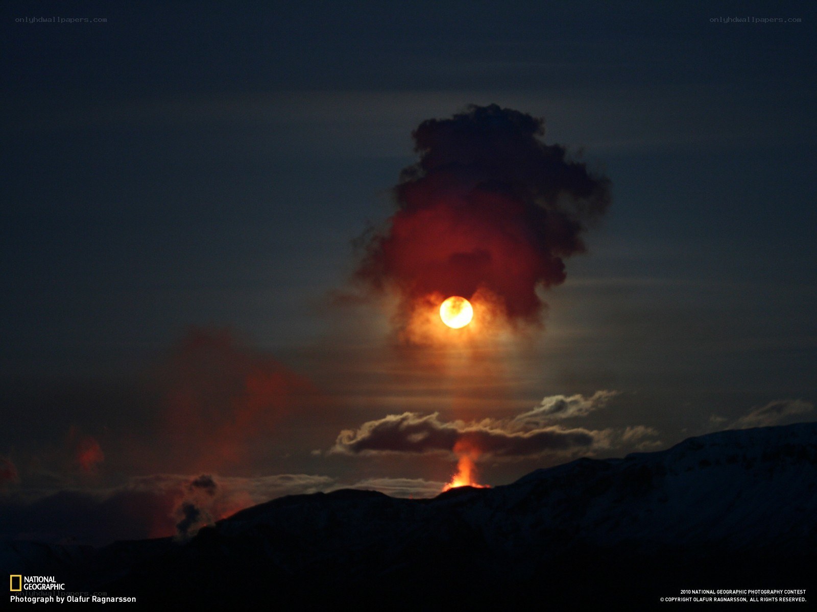Volcano erupting at sunset