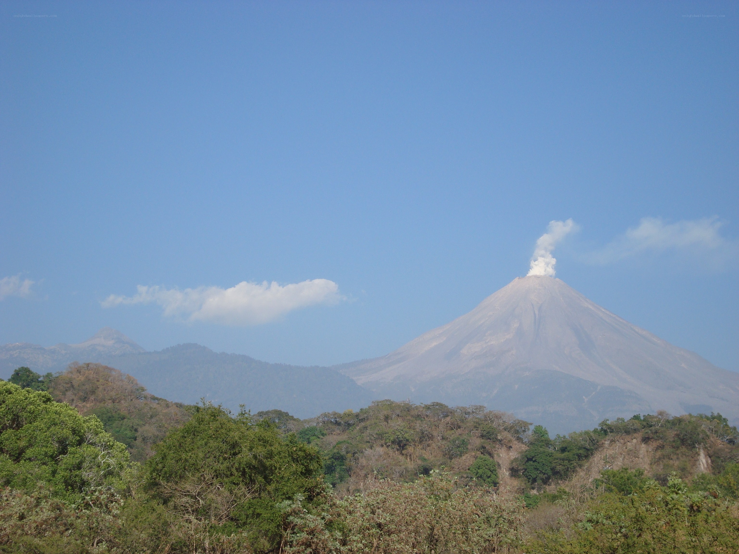 volcano erupting in clear sky