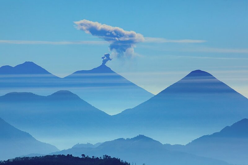 Volcano erupting in mountain range