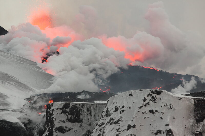 Volcano erupting in snowy landscape