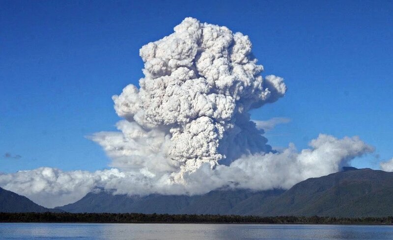 Volcano erupting over a lake