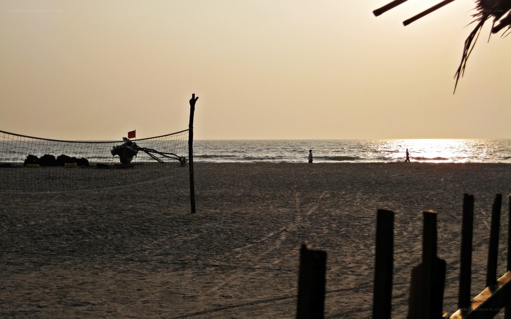 Volleyball net on beach at sunset