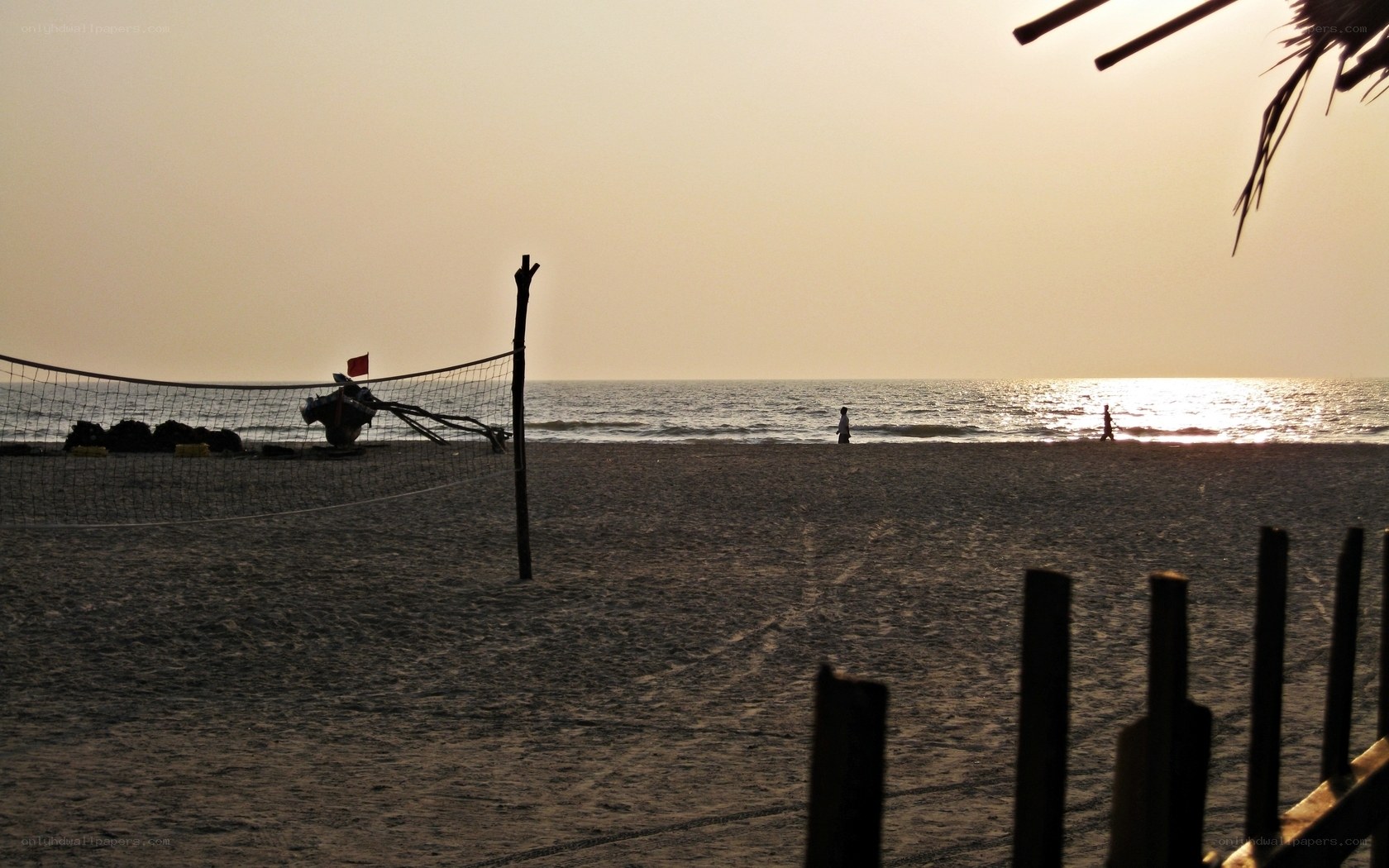 Volleyball net on beach at sunset