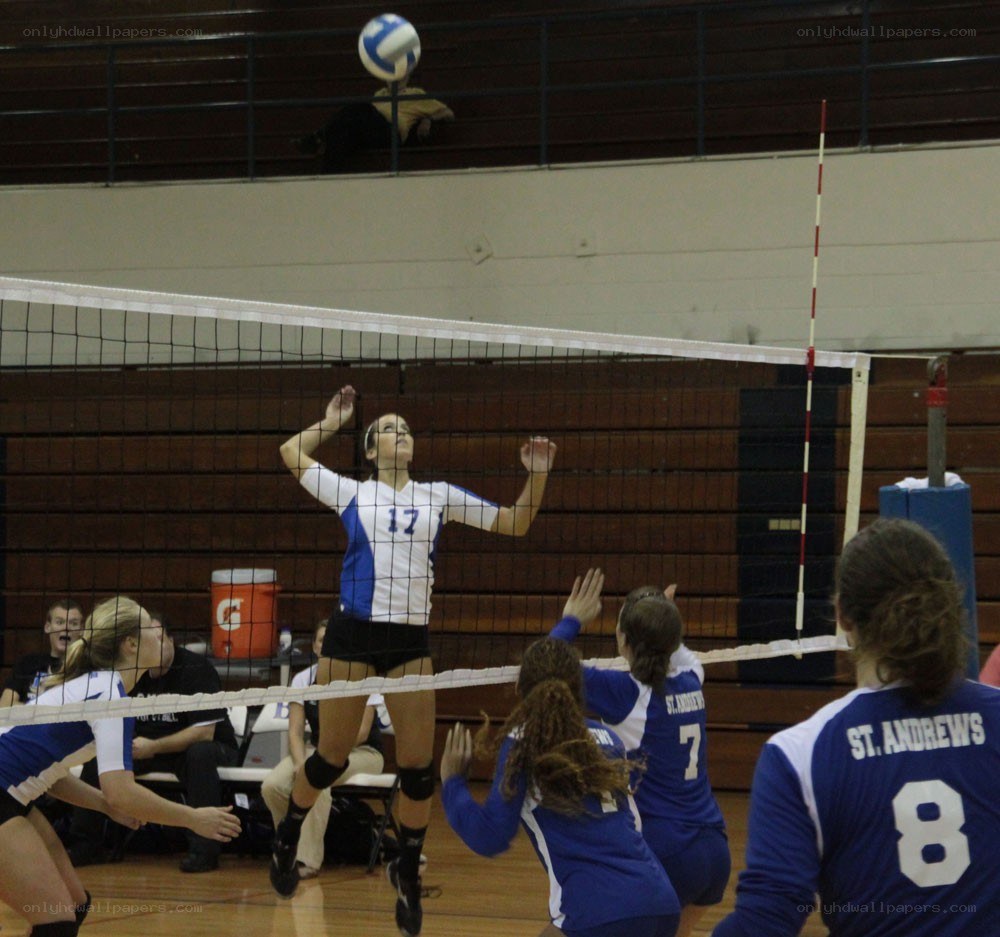 Volleyball player spikes ball